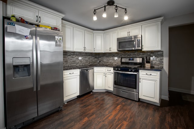 kitchen with backsplash, dark hardwood / wood-style flooring, white cabinets, track lighting, and stainless steel appliances