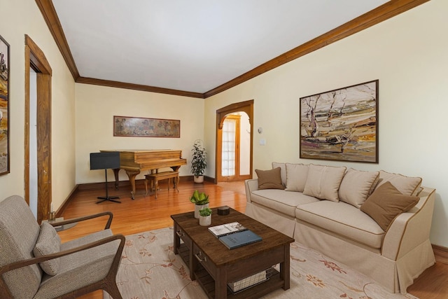 living room with ornamental molding, wood finished floors, and baseboards