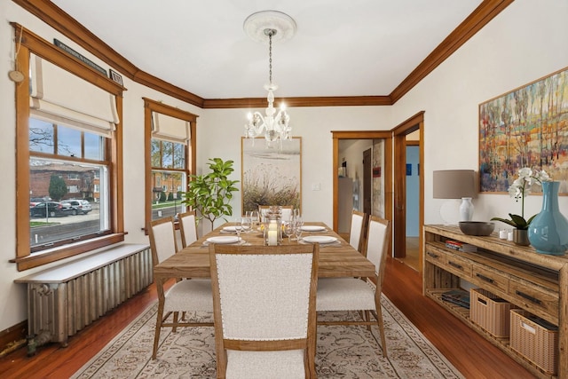 dining room with a chandelier, wood finished floors, baseboards, radiator heating unit, and crown molding