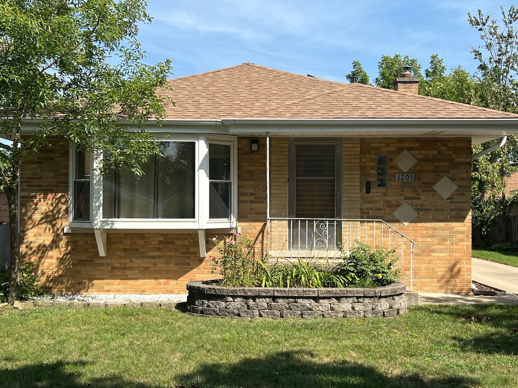 view of front facade featuring covered porch and a front yard