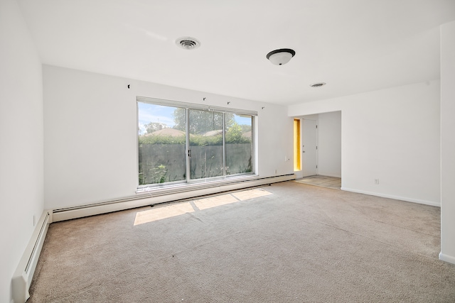 empty room featuring a baseboard heating unit and light colored carpet