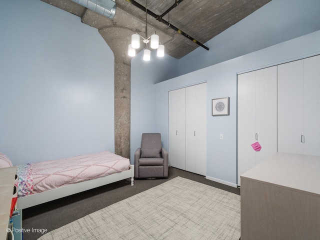 carpeted bedroom featuring two closets and a notable chandelier