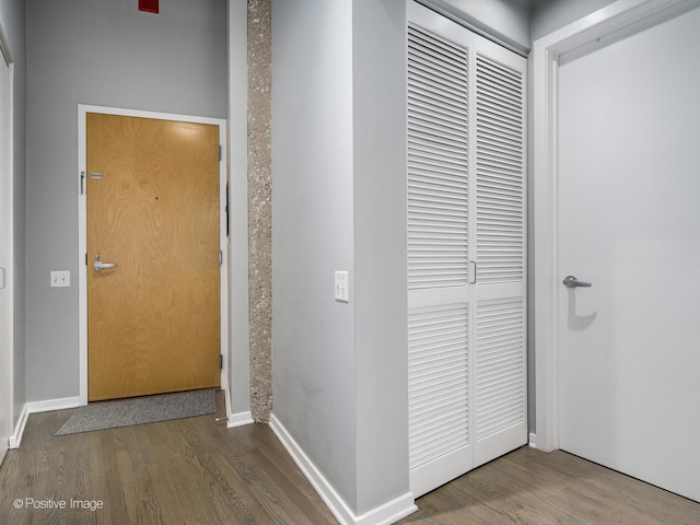 corridor featuring wood finished floors and baseboards