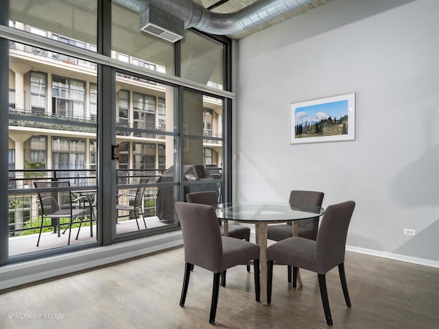 dining area with baseboards, plenty of natural light, and wood finished floors