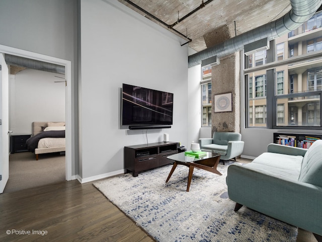 living room featuring wood-type flooring and a towering ceiling