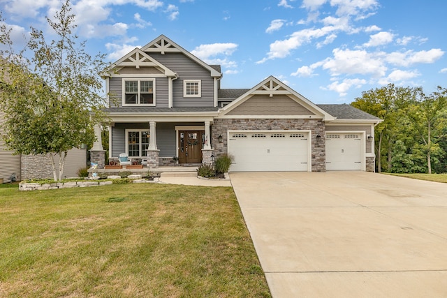 craftsman-style home featuring a garage, covered porch, concrete driveway, and a front yard