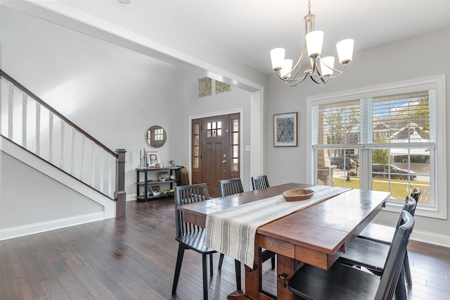 dining room featuring dark wood-style floors, a notable chandelier, baseboards, and stairs