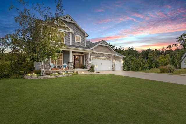 craftsman-style house featuring driveway, an attached garage, a porch, and a front yard