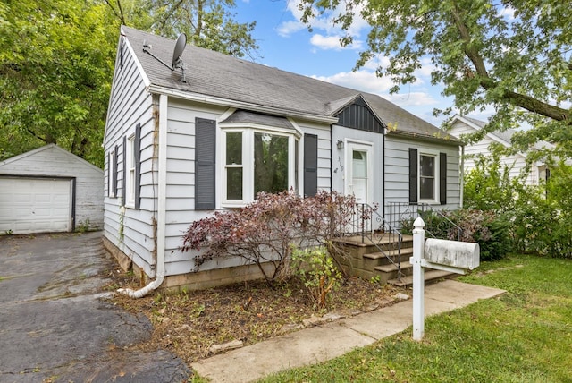 bungalow-style home with a front lawn, an outdoor structure, and a garage