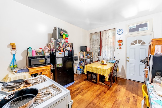 kitchen with black appliances and light hardwood / wood-style flooring