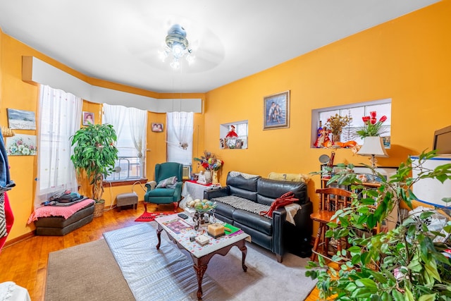 living room with light hardwood / wood-style flooring and ceiling fan