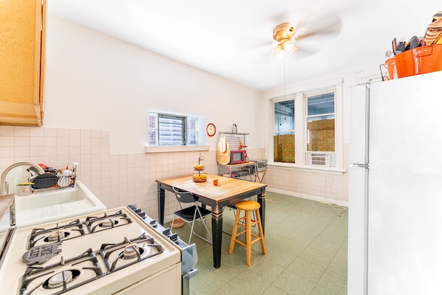 kitchen with tile patterned floors, white appliances, sink, and ceiling fan