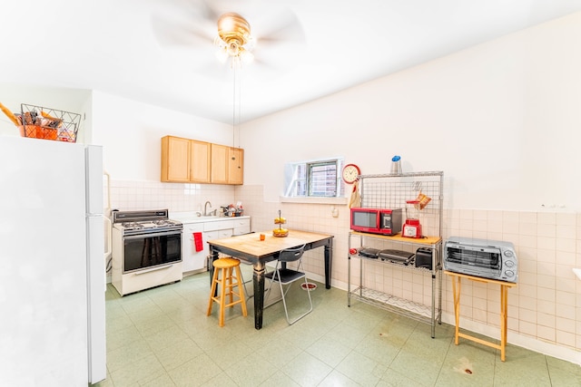 kitchen featuring white appliances, light tile patterned floors, sink, ceiling fan, and light brown cabinets