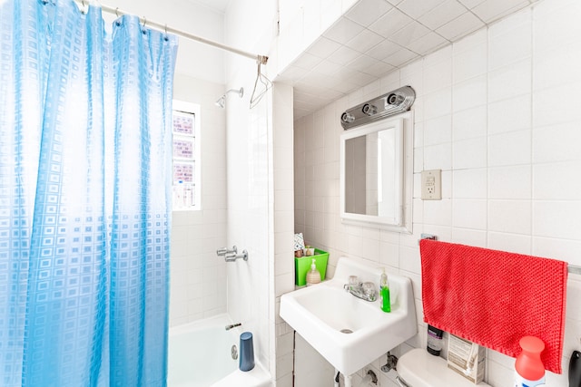 full bathroom with tile walls, shower / bath combination with curtain, toilet, and sink