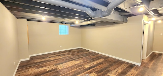 below grade area featuring baseboards and dark wood-type flooring