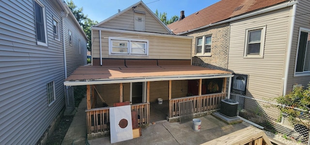 back of property with fence, central AC unit, and a porch