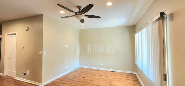 spare room with baseboards, light wood-type flooring, a ceiling fan, and recessed lighting