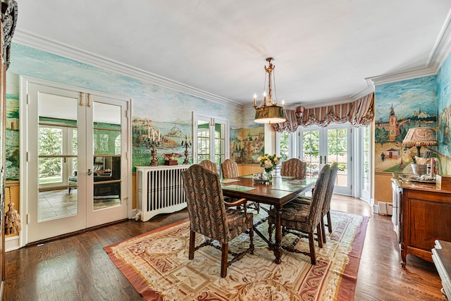 dining room featuring radiator, french doors, ornamental molding, hardwood / wood-style flooring, and a chandelier