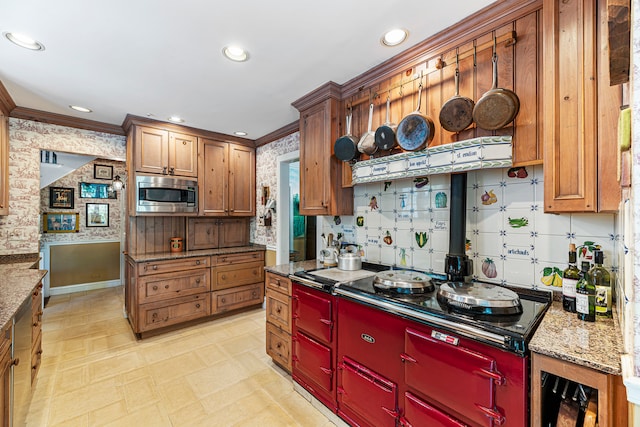 kitchen with ornamental molding, black stovetop, decorative backsplash, light stone counters, and stainless steel microwave