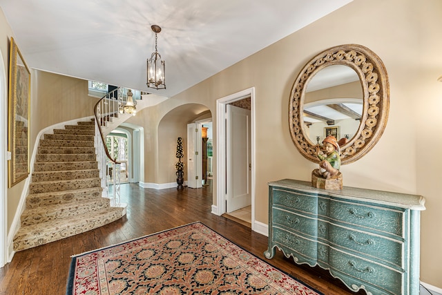 foyer entrance with a chandelier and dark hardwood / wood-style floors