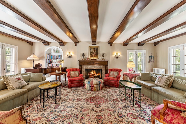 living room with plenty of natural light, beam ceiling, and french doors