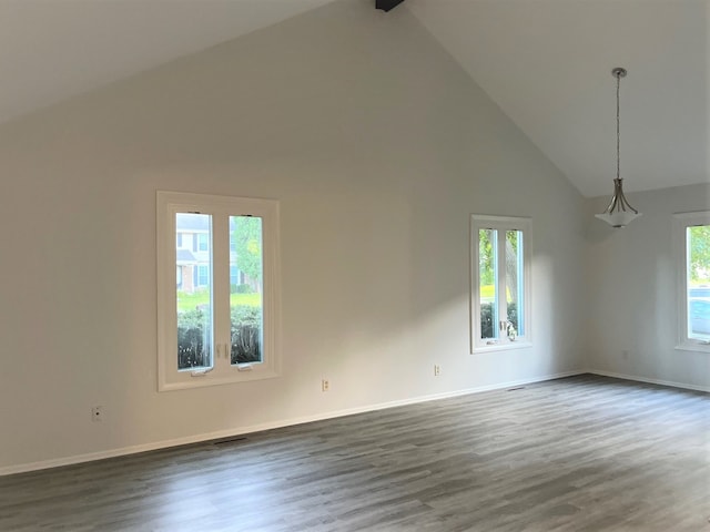 spare room with high vaulted ceiling and dark wood-type flooring