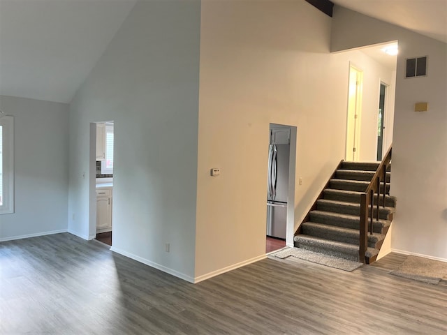 unfurnished living room featuring dark hardwood / wood-style flooring and high vaulted ceiling