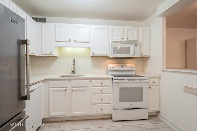 kitchen featuring white cabinets, tasteful backsplash, sink, and white appliances