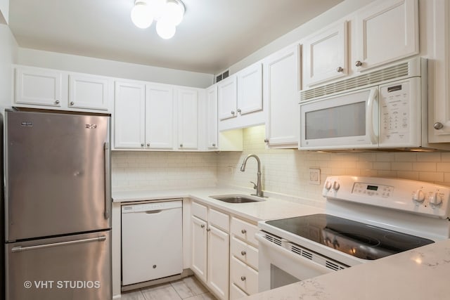 kitchen featuring white cabinets, decorative backsplash, sink, and white appliances