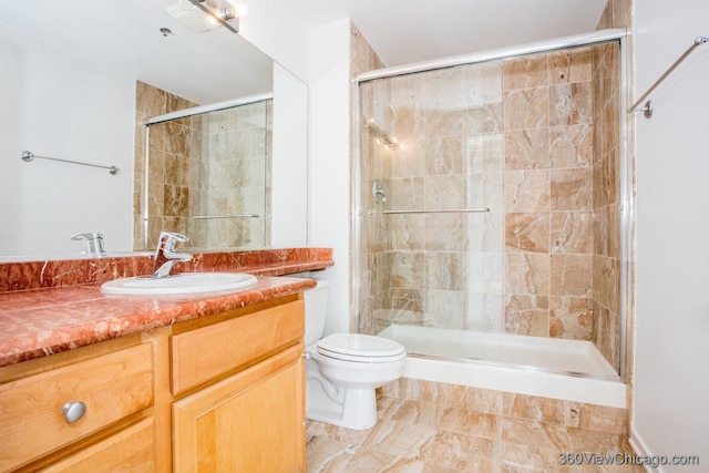 bathroom with toilet, a shower stall, and vanity