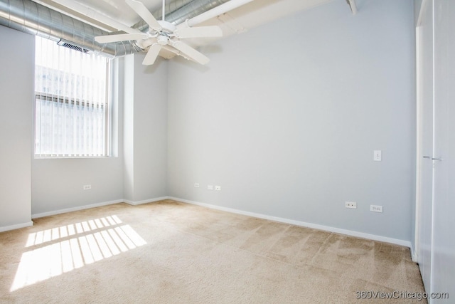 spare room featuring baseboards, carpet, visible vents, and a ceiling fan