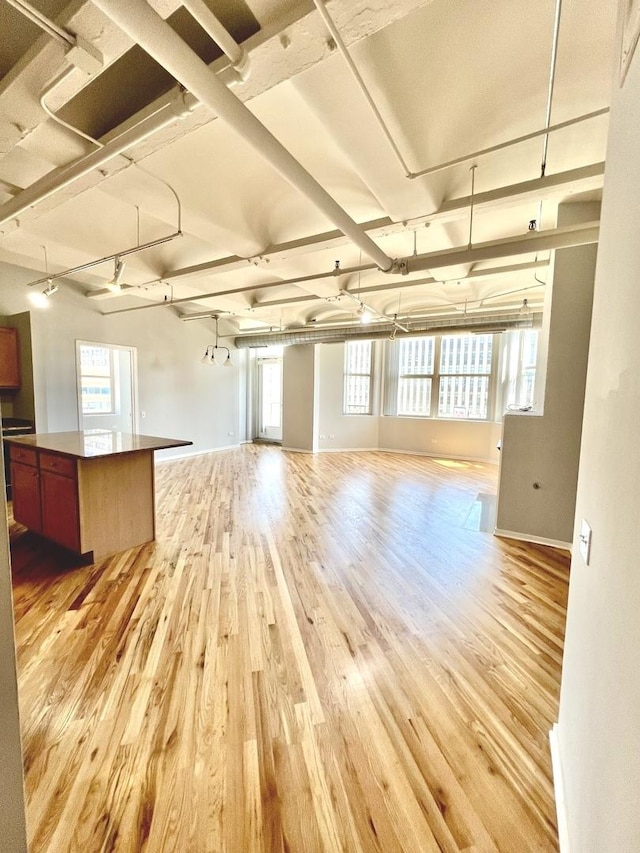 spare room featuring baseboards and light wood finished floors