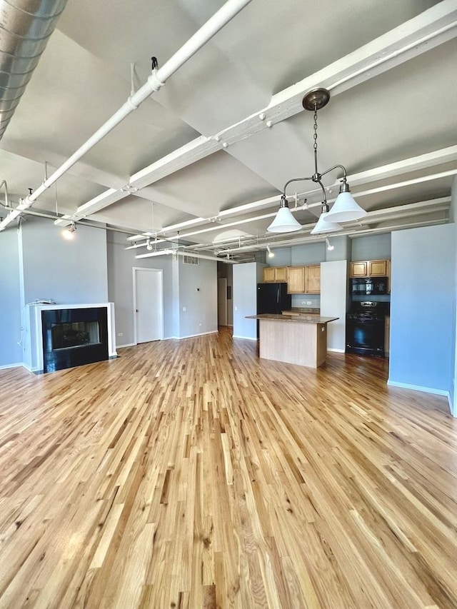 unfurnished living room with light wood-style flooring, a fireplace, and baseboards