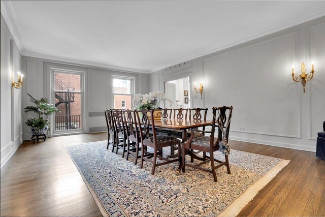 dining area with crown molding and wood-type flooring