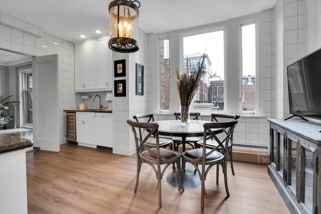 dining area with tile walls, plenty of natural light, and light hardwood / wood-style floors