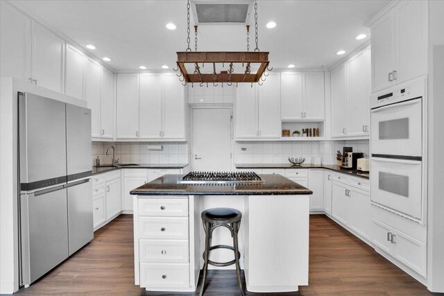 kitchen featuring a center island, stainless steel appliances, backsplash, and dark hardwood / wood-style flooring