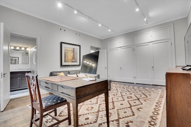 interior space with track lighting, crown molding, and light hardwood / wood-style flooring