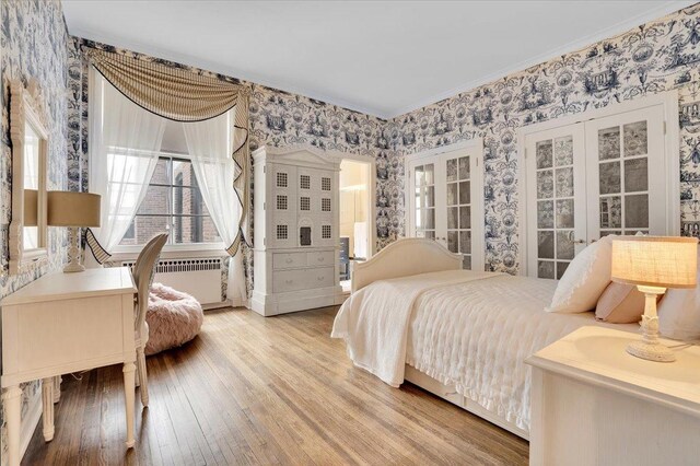 bedroom featuring light wood-type flooring, radiator, and ornamental molding