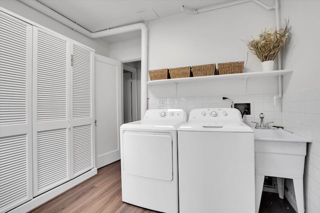 laundry room with hardwood / wood-style flooring and washer and dryer