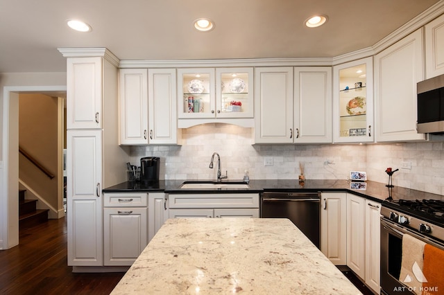 kitchen featuring tasteful backsplash, sink, dark stone countertops, white cabinets, and stainless steel appliances