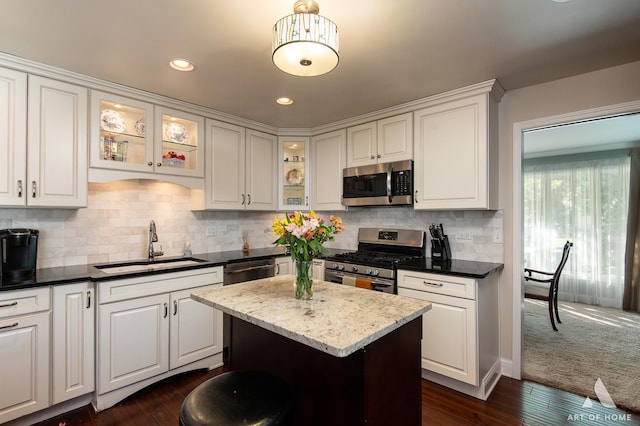 kitchen featuring white cabinetry, sink, stainless steel appliances, and a center island