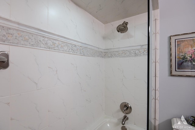 bathroom with toilet and tiled shower / bath combo