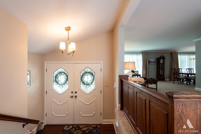 entryway with an inviting chandelier, lofted ceiling, and french doors