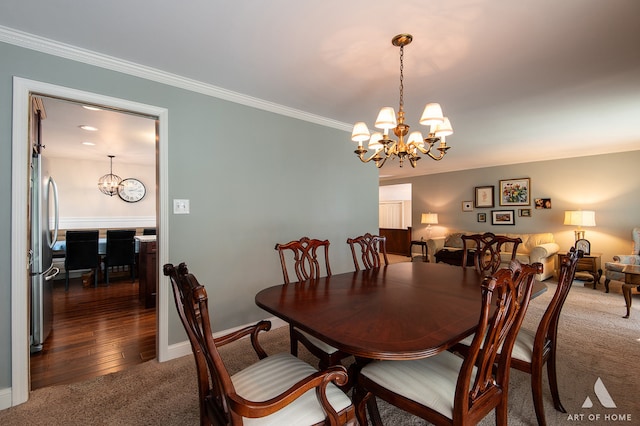 dining area featuring crown molding, a chandelier, and dark colored carpet