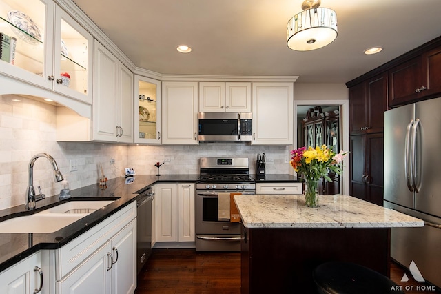 kitchen with tasteful backsplash, sink, dark stone counters, and appliances with stainless steel finishes