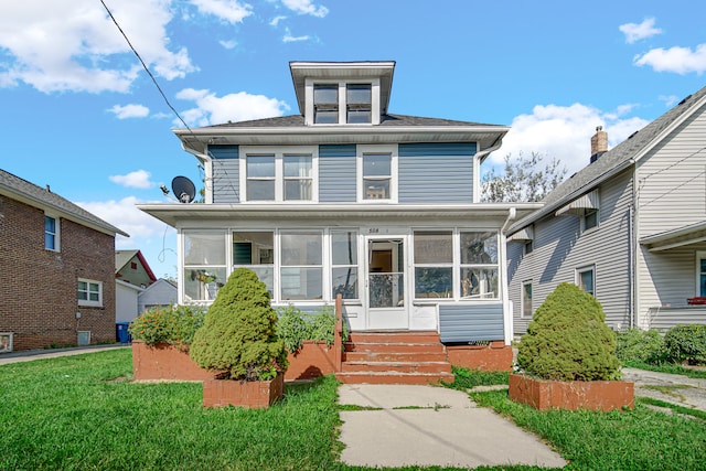 view of front of home featuring a front yard and a sunroom