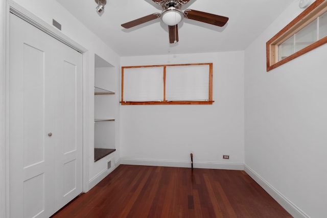 unfurnished bedroom with dark wood-type flooring, ceiling fan, and a closet