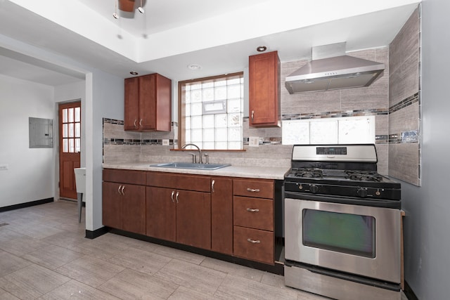 kitchen with light tile patterned floors, sink, electric panel, stainless steel gas stove, and wall chimney range hood