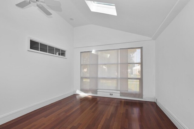 spare room with plenty of natural light, dark wood-type flooring, ceiling fan, and lofted ceiling with skylight