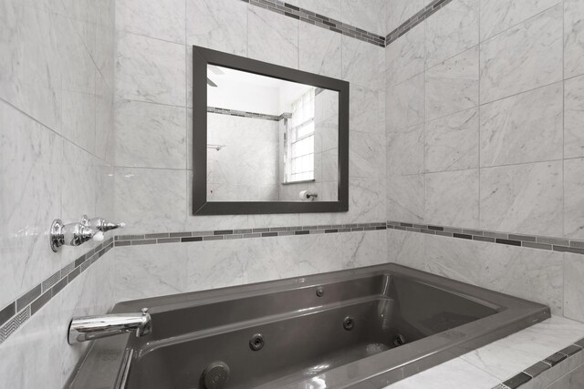 bathroom featuring tile walls and tiled tub